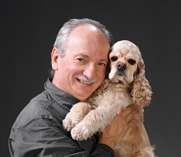 Foto uomo felice con un cane su uno sfondo grigio