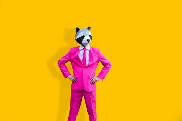 Happy man with funny low poly mask on colored background