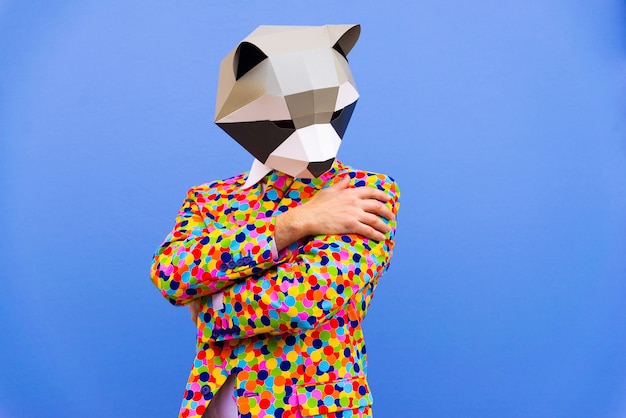 Happy man with funny low poly mask on colored background