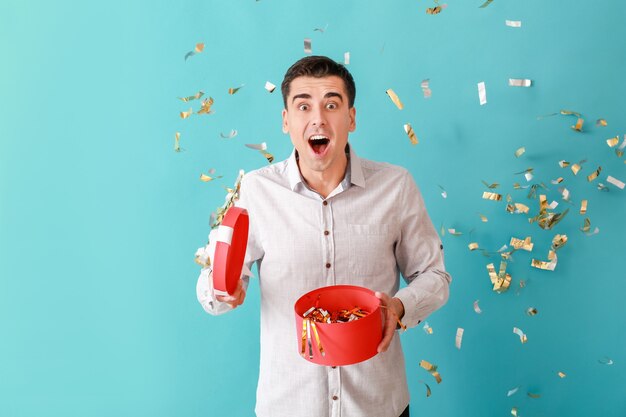 Happy man with gift and falling confetti