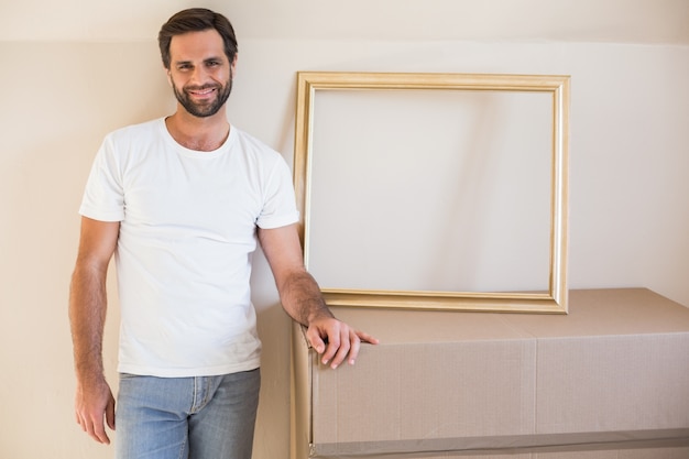 Happy man with moving boxes and frame