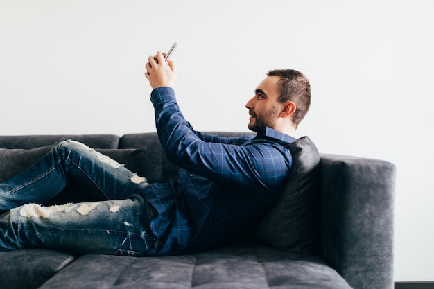 happy man with smartphone having video call at home