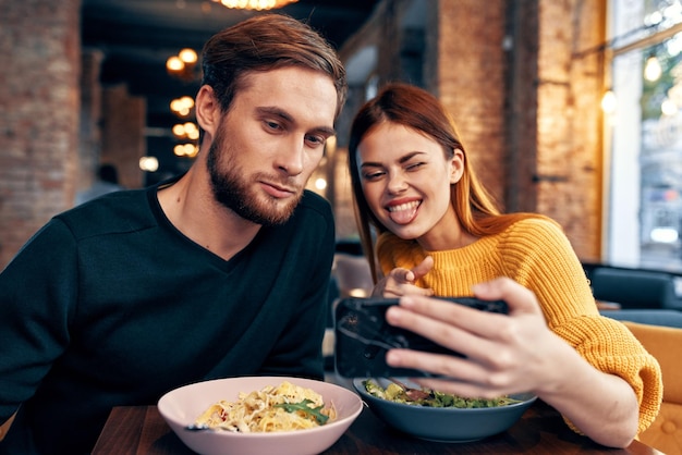 カフェで幸せな男女の楽しい友人の食べ物