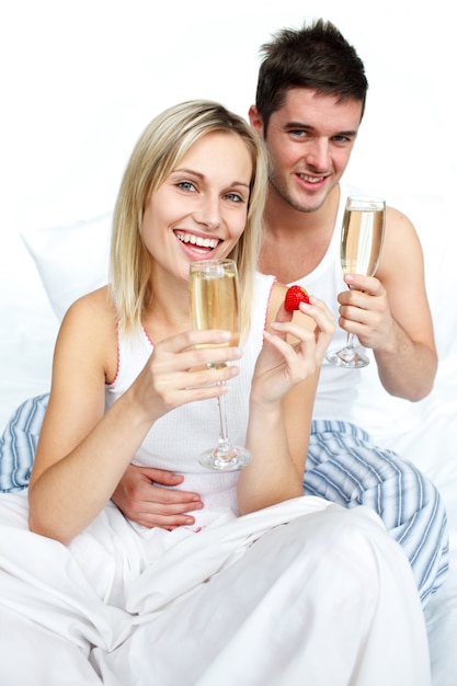 Happy man and woman celebrating an engagement with champagne