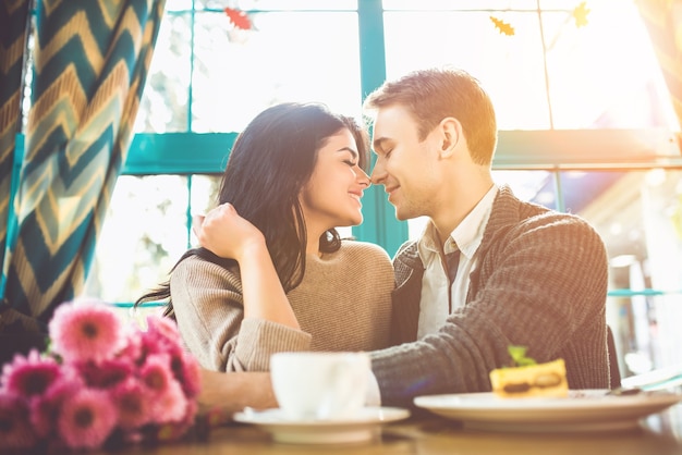 幸せな男性と女性はカフェでロマンチックなデートをしています