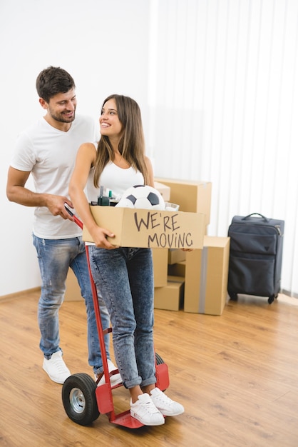 Счастливые мужчина и женщина переезжают в новую квартиру