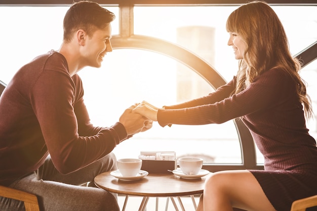 Foto l'uomo felice e una donna si siedono al tavolo del ristorante