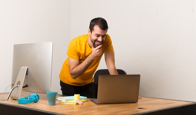 Happy man working with laptot in a office