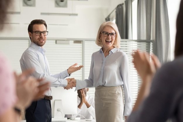 Happy manager boss praising old employee for good work get team\
appreciation acknowledgement handshaking successful worker\
congratulating promoting rewarding welcoming new partner respect\
handshake