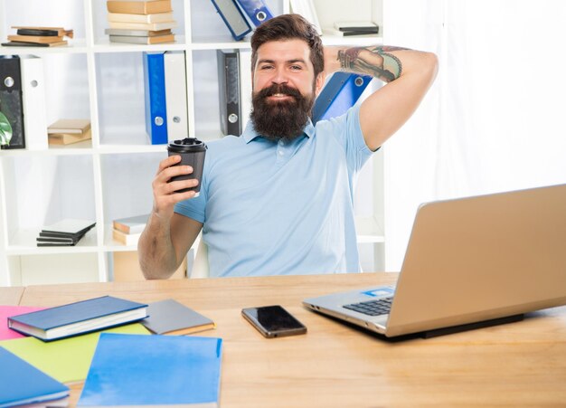 Happy manager relaxing in office during coffee break relaxation