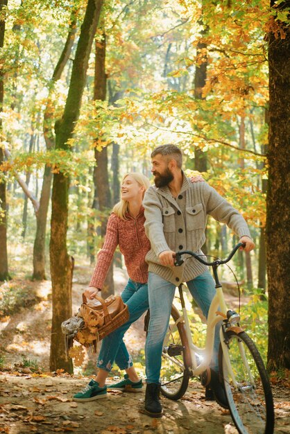 Happy marriage couple having a picnic in the forest cycling a bicycle real love beautiful young coup