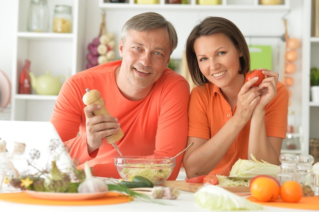 Happy married couple cooking together on kitchen at home