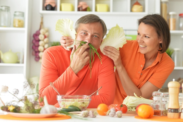 Coppia sposata felice che cucina insieme sulla cucina