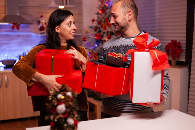 Happy married couple holding secret present gift with ribbon on it