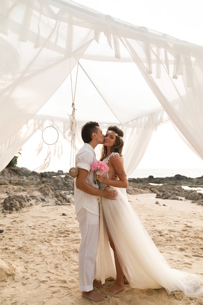 Foto la coppia sposata felice sta celebrando il loro matrimonio sulla spiaggia dell'isola tropicale