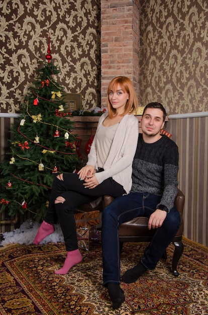 happy married couple together by the tree at christmas