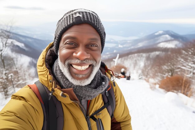 Happy mature african american hiker man taking selfie portrait on top of a snowy mountain