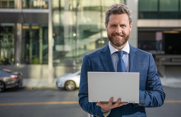 Happy mature business man in formalwear work on modern laptop outdoor copy space presentation