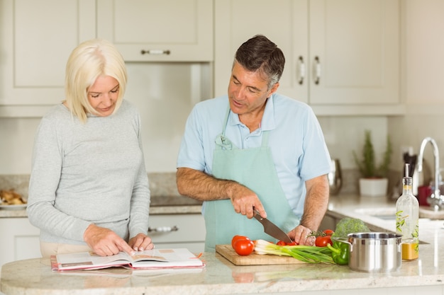 Happy mature couple following a vegetarian recipe