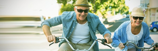 Happy mature couple going for a bike ride in the city on a sunny day