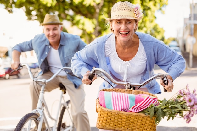 都市で自転車に乗る幸せな成熟したカップル