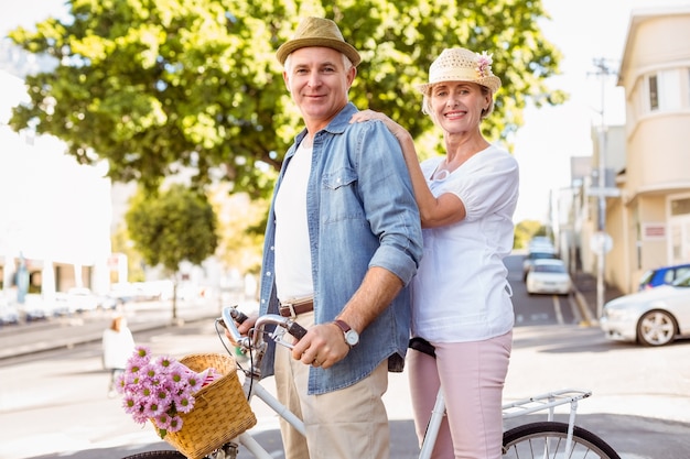 Happy mature couple going for a bike ride in the city