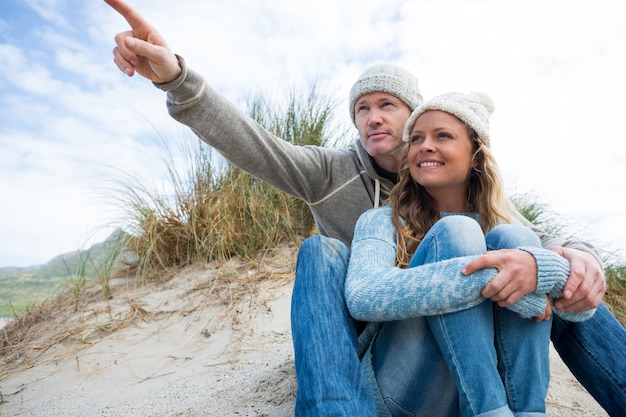 Happy mature couple pointing at view