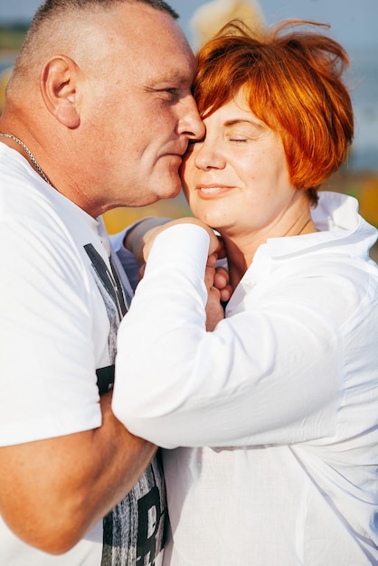 Happy mature couple pose on sunny day on the beach