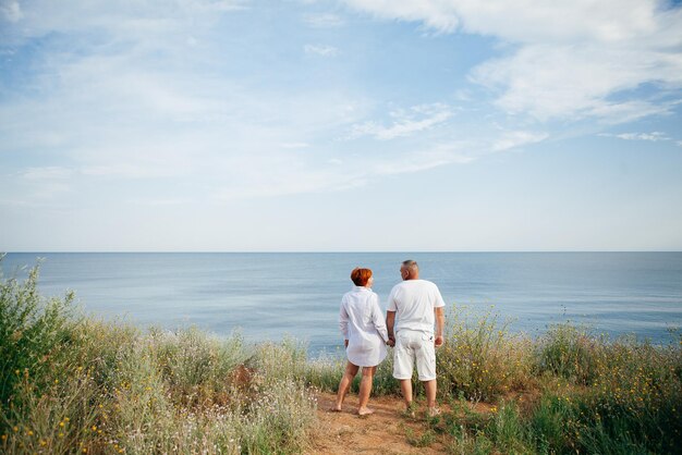 Happy mature couple pose on sunny day on the beach