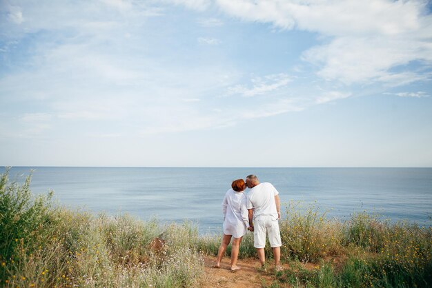 Happy mature couple pose on sunny day on the beach