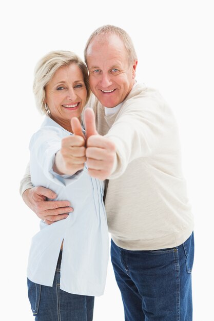 Happy mature couple showing thumbs up