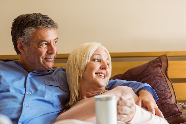 Happy mature couple smiling on bed