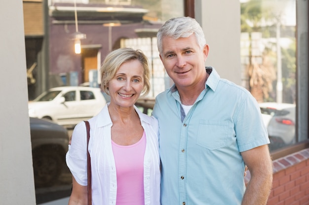 Happy mature couple smiling at camera in the city