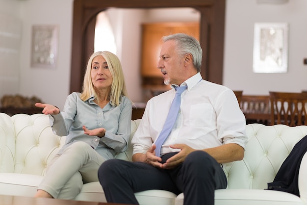 Coppie mature felici che parlano nella loro casa