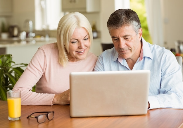 Happy mature couple using laptop