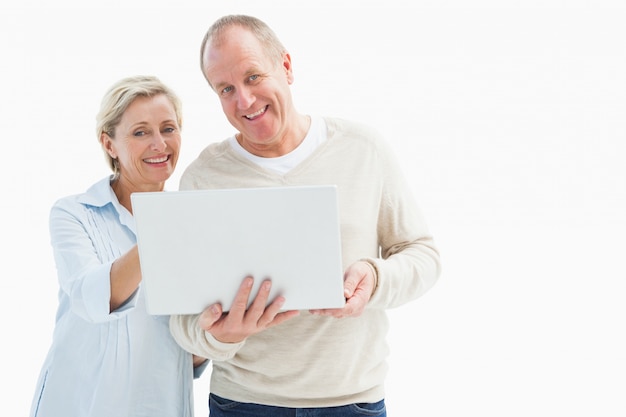 Happy mature couple using laptop