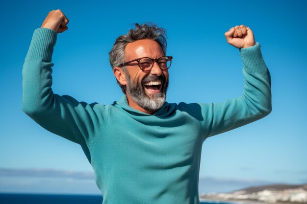 Un uomo maturo felice che celebra il successo con le braccia alzate.