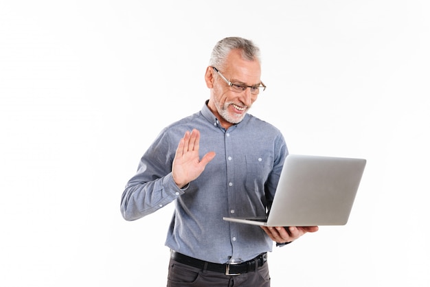 Happy mature man making videocall with laptop computer isolated