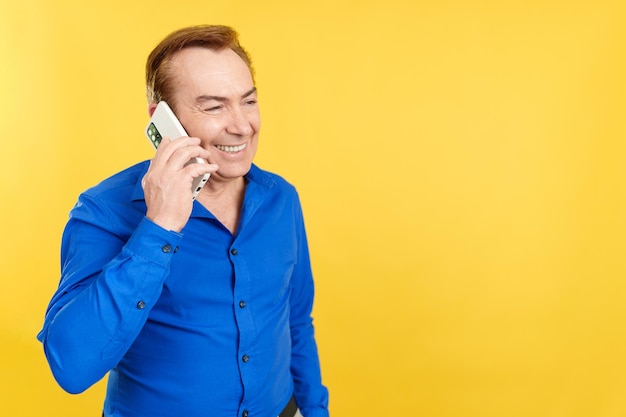 Счастливый зрелый мужчина разговаривает с мобильным телефоном