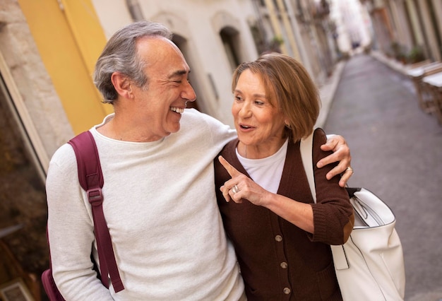 Happy mature man and woman talking while walking in lisbon