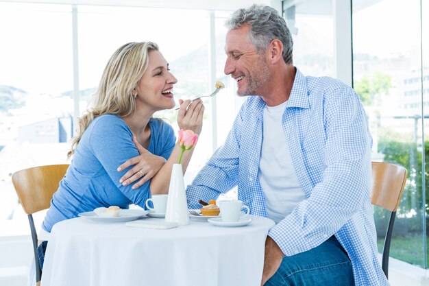 Happy mature woman feeding man