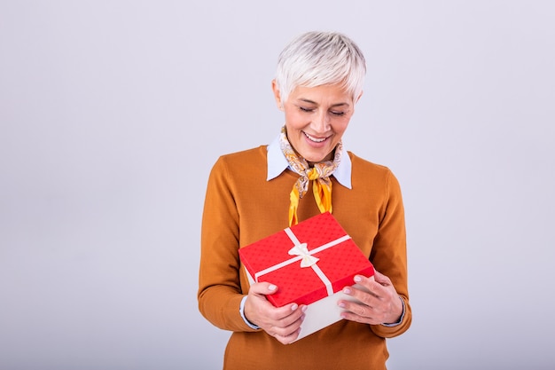 Happy mature woman holding gift box