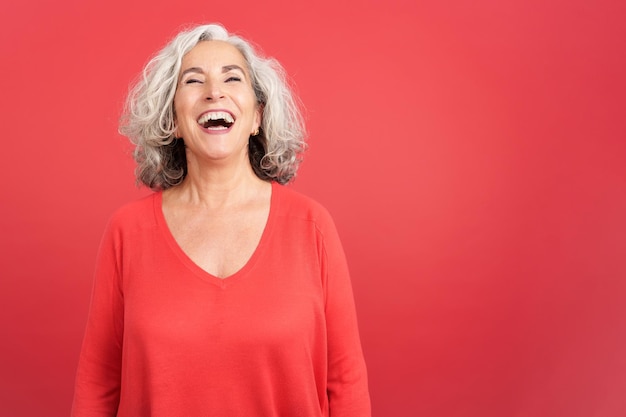 A happy mature woman laughing while standing