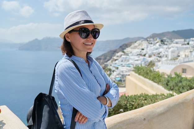 Happy mature woman tourist traveling on famous island Santorini