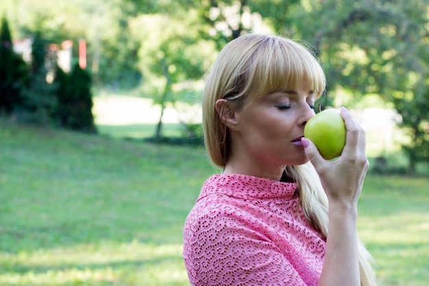 Happy mature woman with green apple