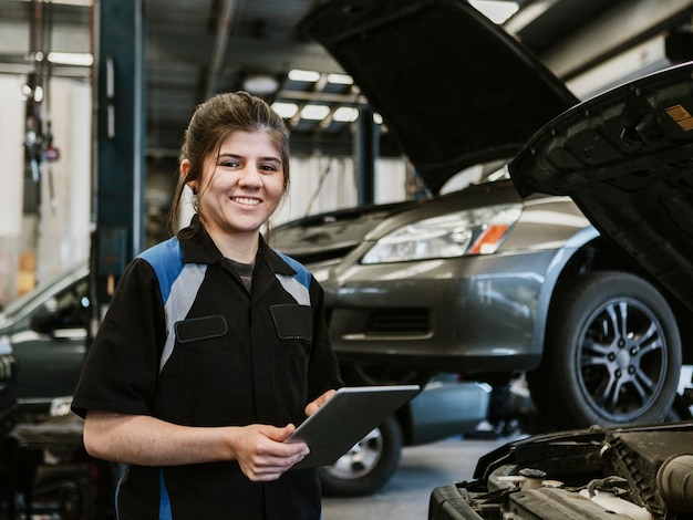 Happy mechanic running a diagnostic on a vehicle