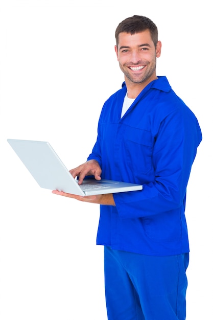 Happy mechanic using laptop on white background