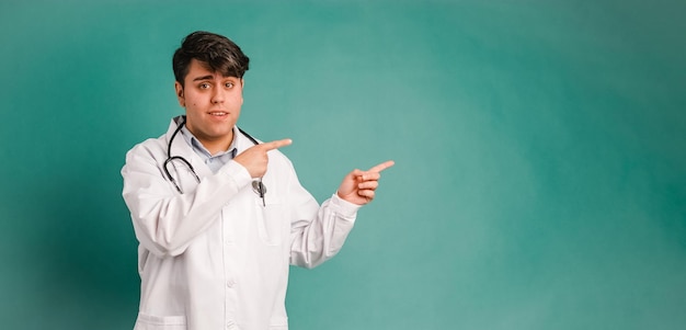 Happy medical professional pointing on green background