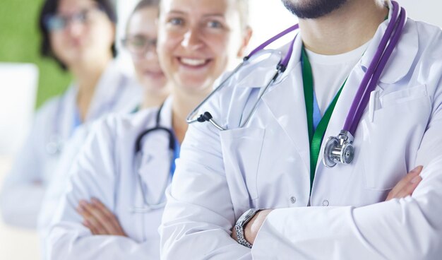 Happy medical team comprising male and female doctors smiling broadly and giving a thumbs up of success and hope