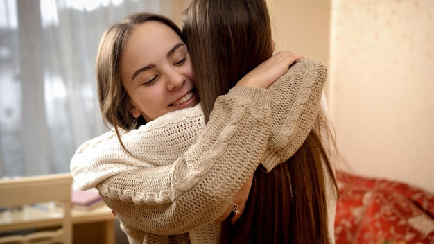 Photo happy meeting of two smiling teenage girls at home